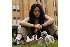 Image Woman eating junk food sitting on the grass